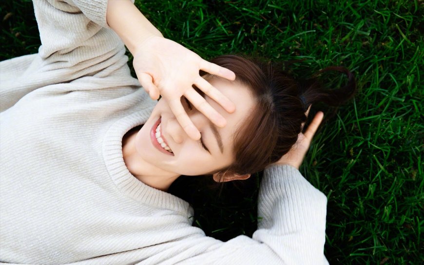 草地上笑容甜美的美女图片壁纸