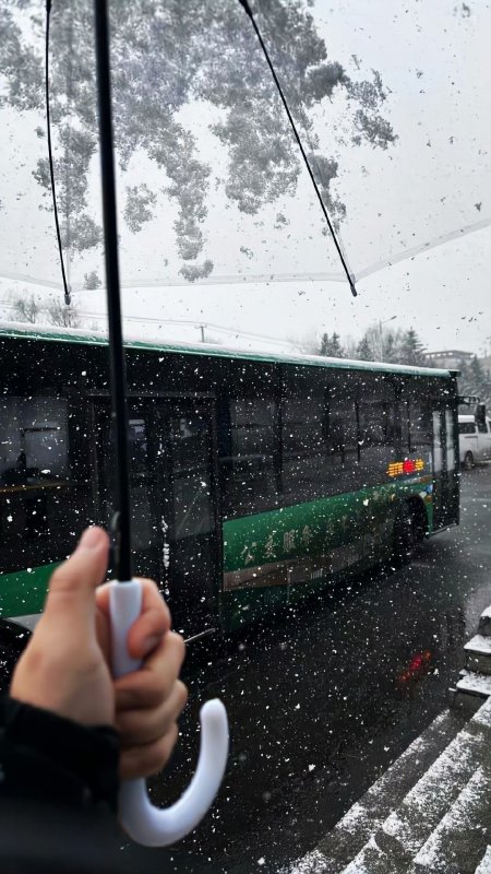 下雪天公交站台手持伞纪实风手机壁纸