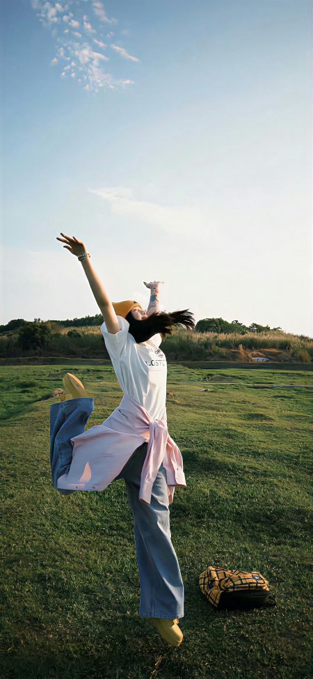 草地女生跳跃活力青春人像手机壁纸