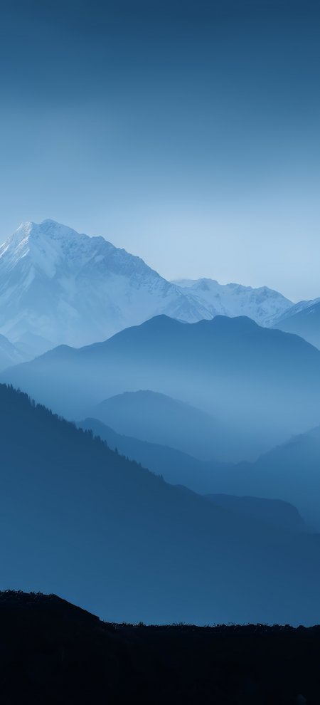 层叠雪山与蓝色晨雾的壮丽自然风光手机壁纸