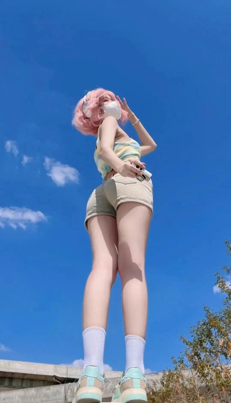 粉色卷发少女戴口罩持相机仰拍蓝天手机壁纸