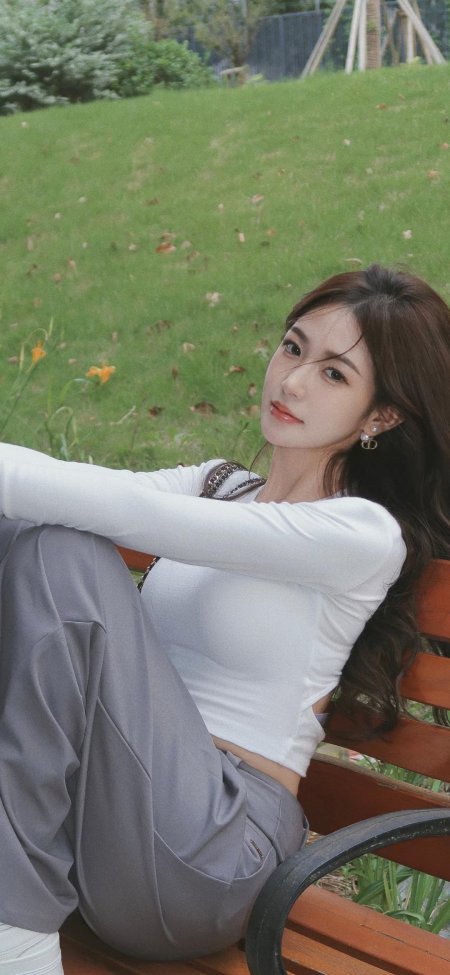 户外公园长椅上白衣灰裤年轻女性侧坐回眸手机壁纸