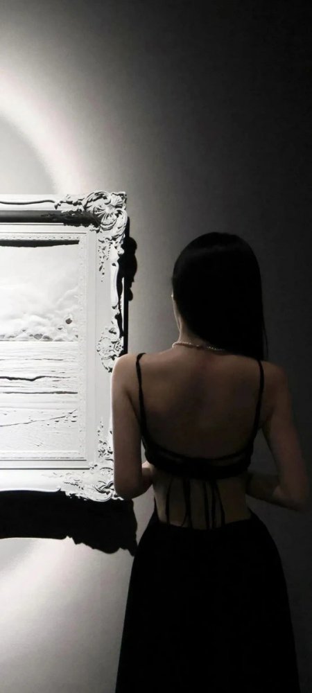 黑裙女子背影凝视白色雕花画框艺术展手机壁纸