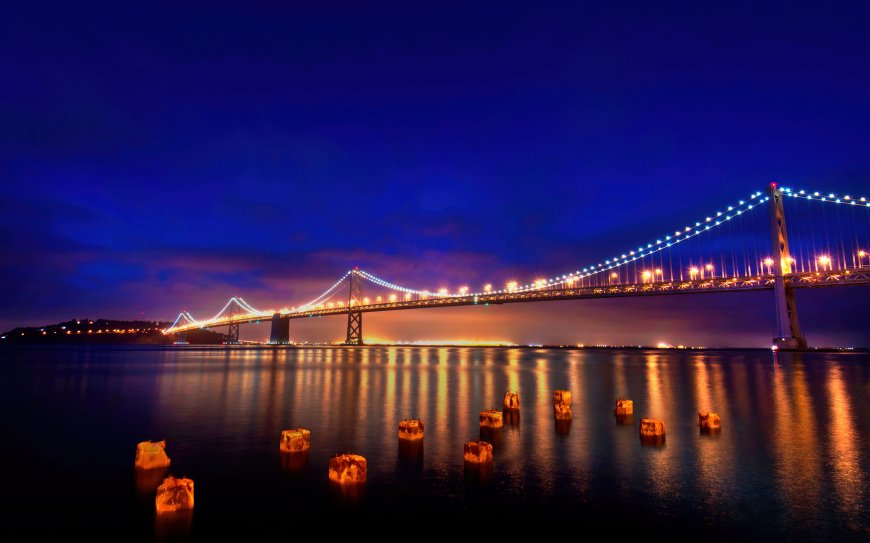 旧金山海湾大桥夜景灯光水面上的木桩倒影蓝色天空城市景观风景电脑壁纸