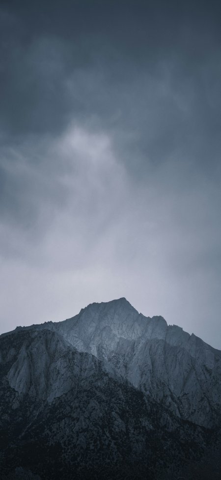 乌云笼罩下的巍峨雪山冷峻自然风光手机壁纸