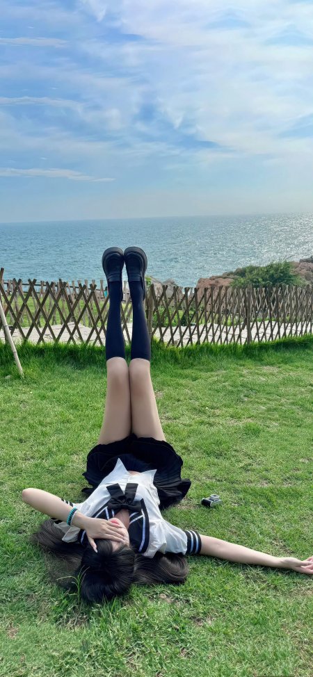少女穿水手服躺在草地双腿向上海边风景人物手机壁纸