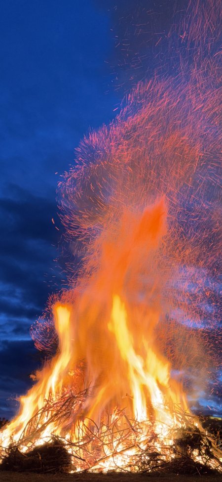篝火燃烧火花四溅夜空下的温暖场景手机壁纸