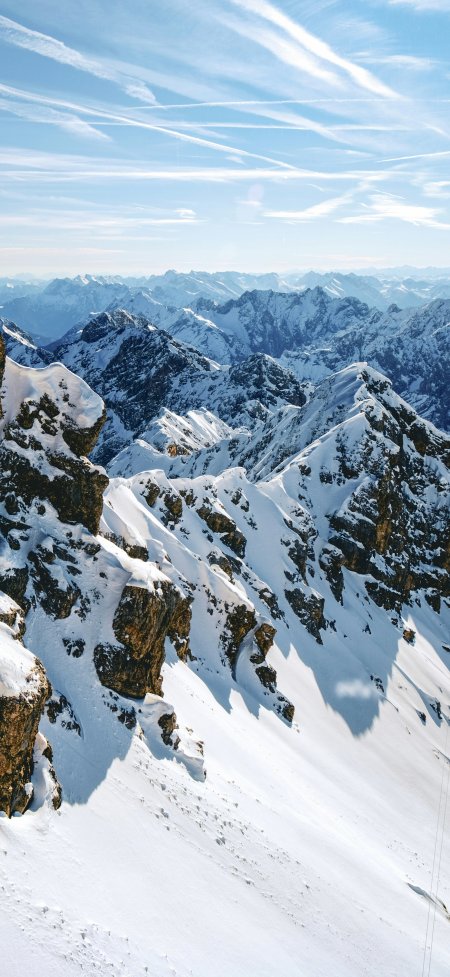 连绵雪峰阳光照耀阿尔卑斯山脉壮丽风景手机壁纸