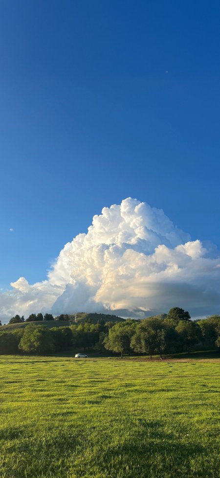 积雨云下绿草地白车停靠自然风景手机壁纸