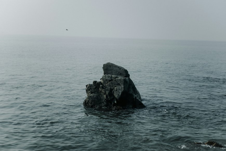 海中孤石海浪轻拍雾气弥漫自然静谧风景电脑壁纸