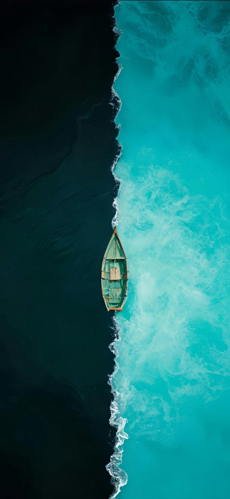 小舟漂浮在深蓝与碧绿水域交界处的风景手机壁纸