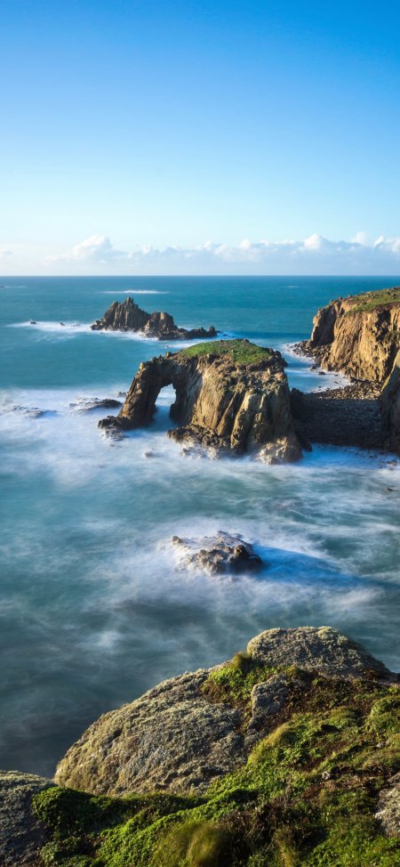海浪拍打岩石拱门的海岸线风景手机壁纸