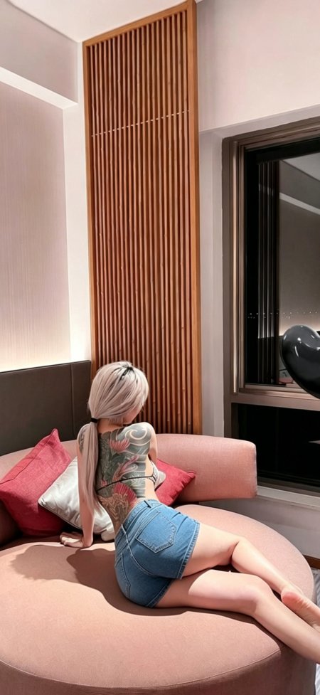 银发美女背部纹身牛仔短裙坐粉色沙发人物手机壁纸
