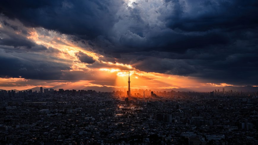 东京晴空塔矗立城市中央夕阳穿透厚重云层洒下金色光束壮丽都市风景摄影电脑壁纸