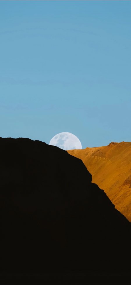 月亮悬于山巅蓝黄渐变天空静谧自然风景手机壁纸