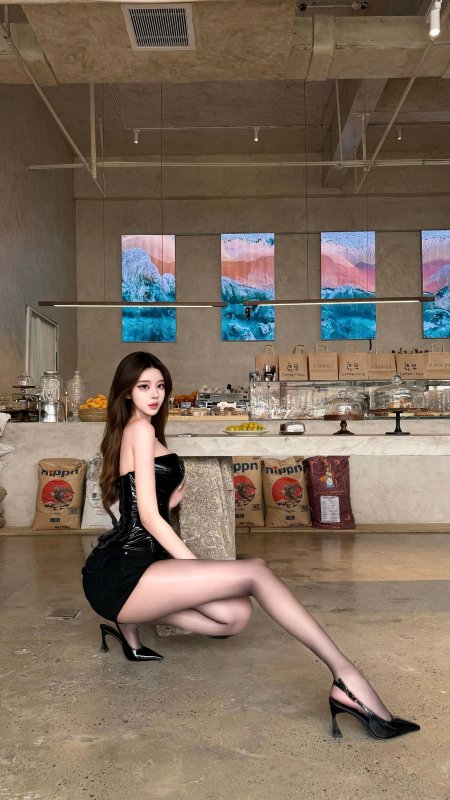 美女黑色漆皮连体衣蹲姿拍摄工业风咖啡馆时尚人物摄影手机壁纸