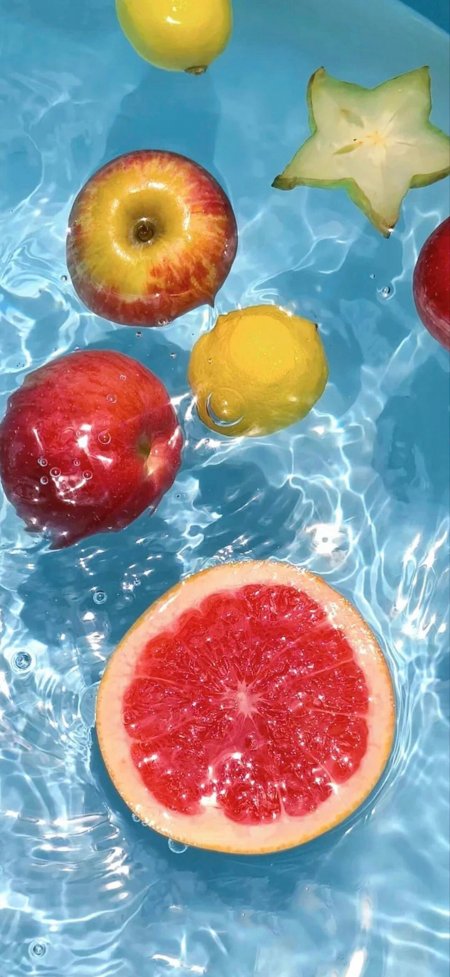 苹果葡萄柚杨桃漂浮蓝色水面光影斑驳水果特写手机壁纸