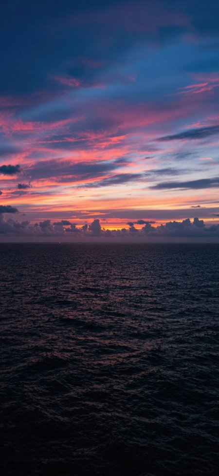 粉紫晚霞海岸线暗色海面静谧治愈风景手机壁纸