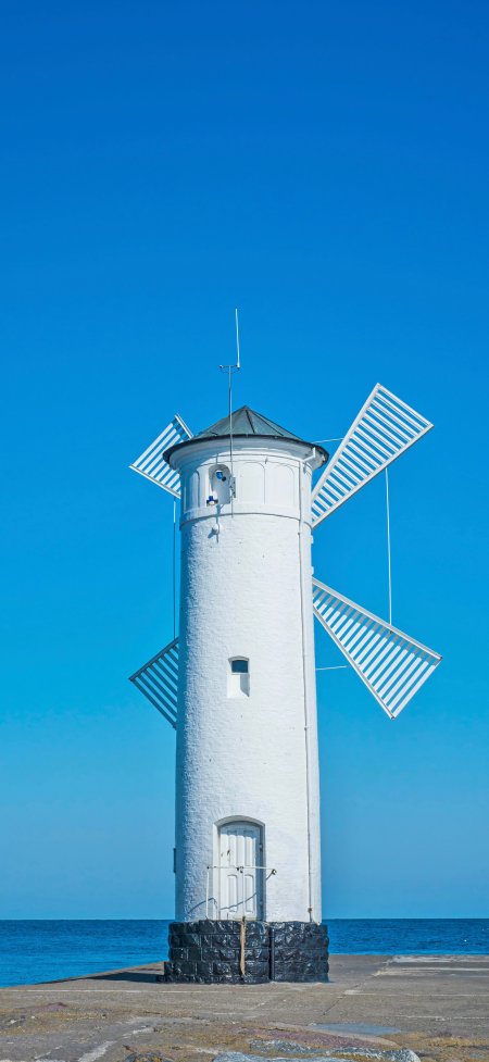 风车灯塔蓝天碧海白色建筑风景手机壁纸