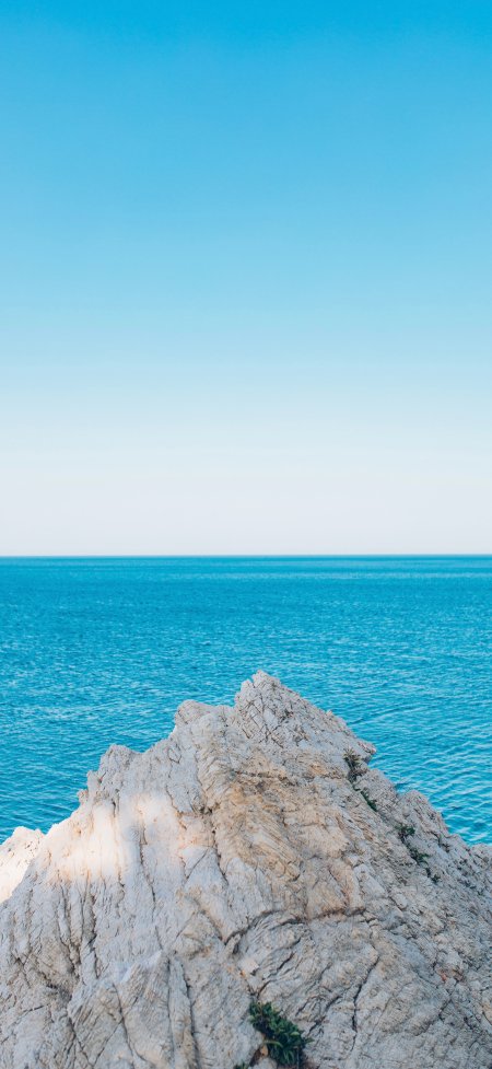 白岩礁石深蓝大海晴空简约风景手机壁纸