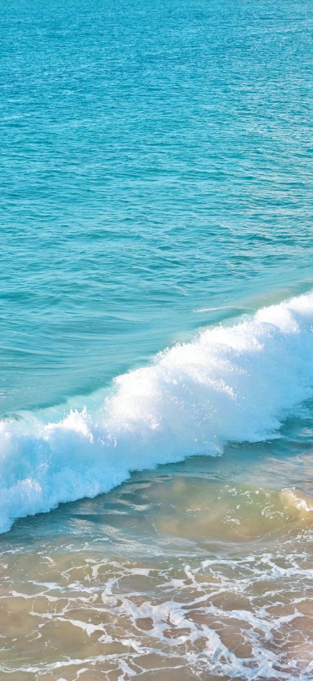 俯拍蓝色海浪洁白浪花沙滩风景手机壁纸