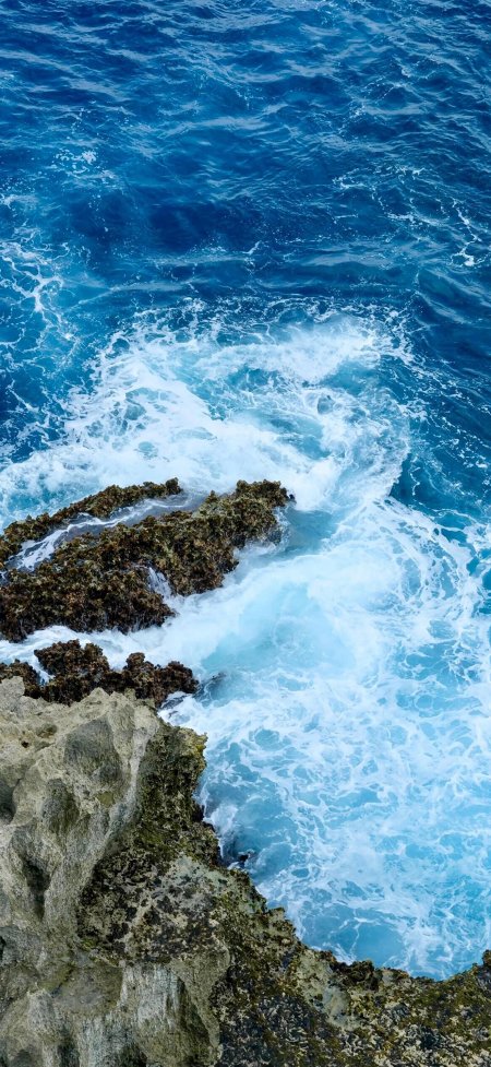 俯拍深蓝海洋礁石白色浪花壮观风景手机壁纸
