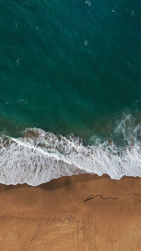 俯拍蔚蓝海洋海浪金色沙滩足迹风景手机壁纸