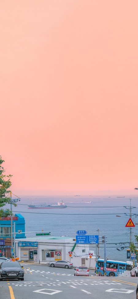 粉色晚霞海滨公路货轮小镇风景手机壁纸