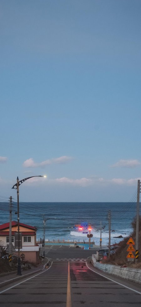 暮色沿海公路尽头大海小镇灯光风景手机壁纸