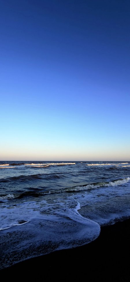 海浪轻拍黑沙滩蓝渐变风景手机壁纸