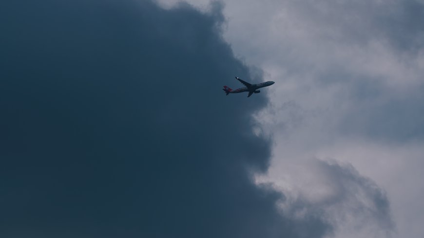 客机穿云而过灰蓝天空风景电脑壁纸