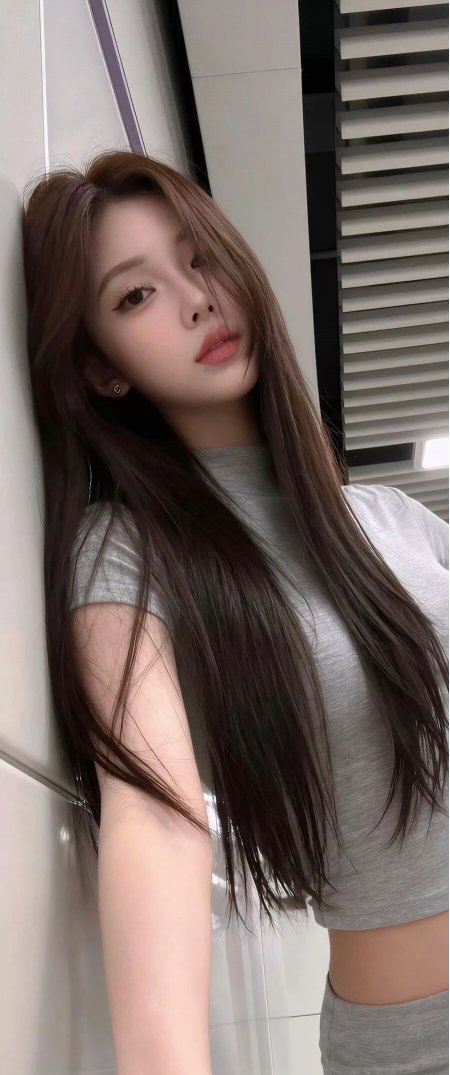 长发美女倚墙浅笑灰白人物摄影手机壁纸
