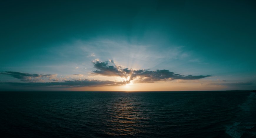 海面日落金光穿透云层蓝金风景电脑壁纸