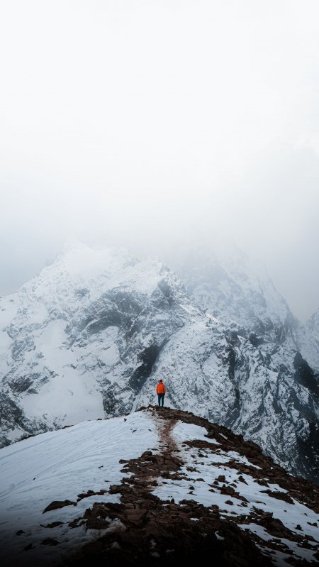 雪山之巅橙衣旅人孤影白灰风景手机壁纸