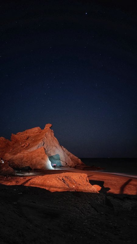 星空下的红色岩洞海滩夜景蓝黑风景手机壁纸