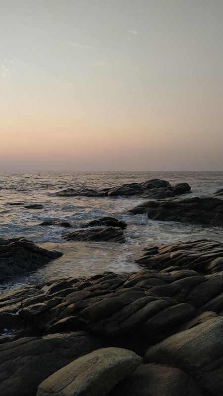 海边礁石浪花拍岸暖橙风景手机壁纸
