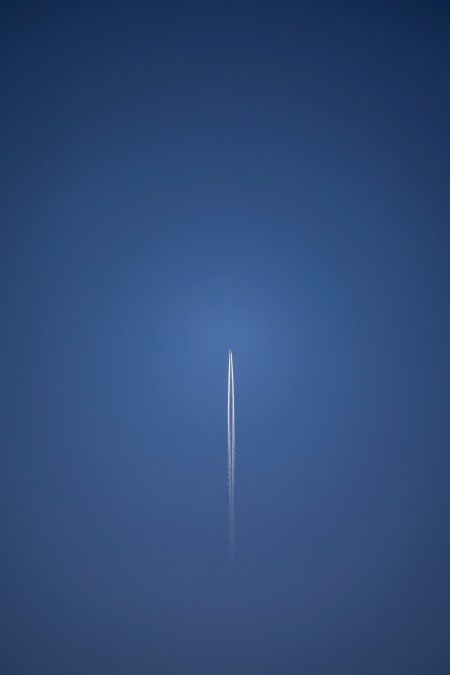 飞机尾迹划破深蓝天空暗蓝飞机手机壁纸