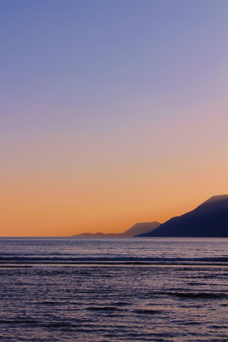 海面日落山影渐变紫橙风景手机壁纸
