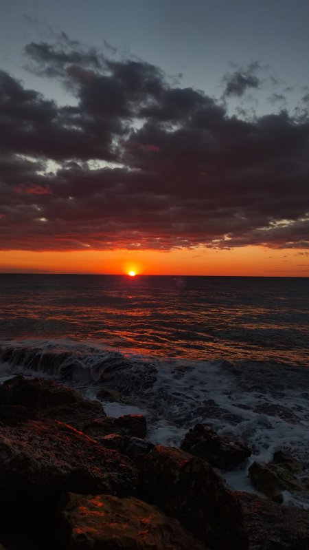 海面日落余晖染红云层暗金风景手机壁纸