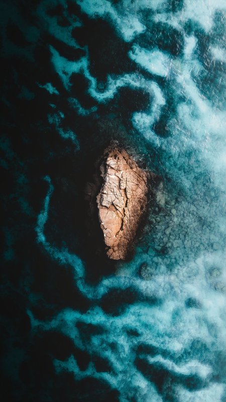 海中孤岩俯瞰蓝黑漩涡风景手机壁纸
