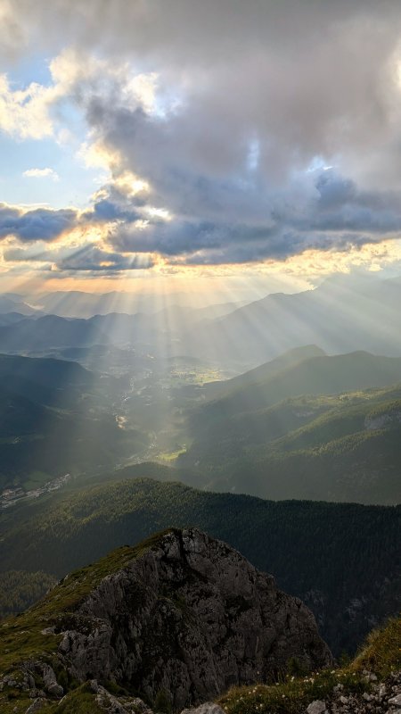 阿尔卑斯山峰云隙光束穿透山谷蓝金风景手机壁纸