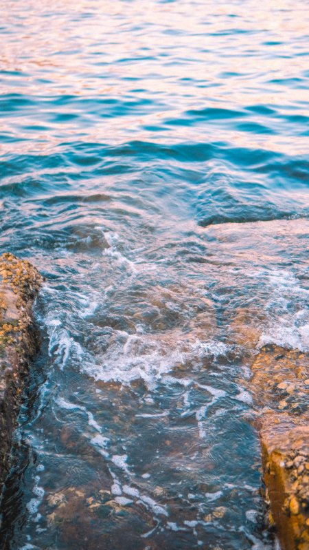 海浪拍打礁石蓝粉渐变风景手机壁纸