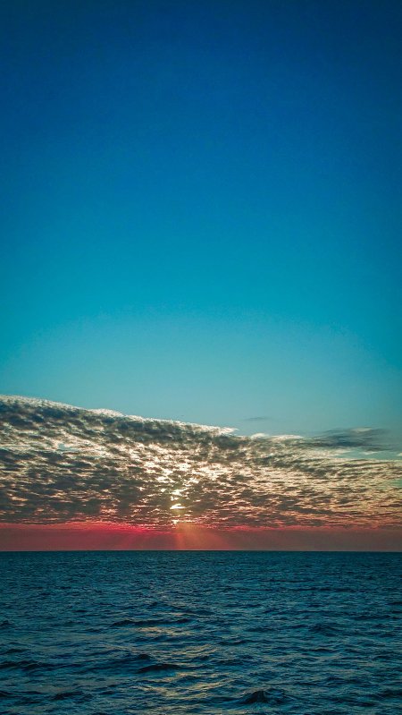 海面日落云层透光蓝红渐变风景手机壁纸