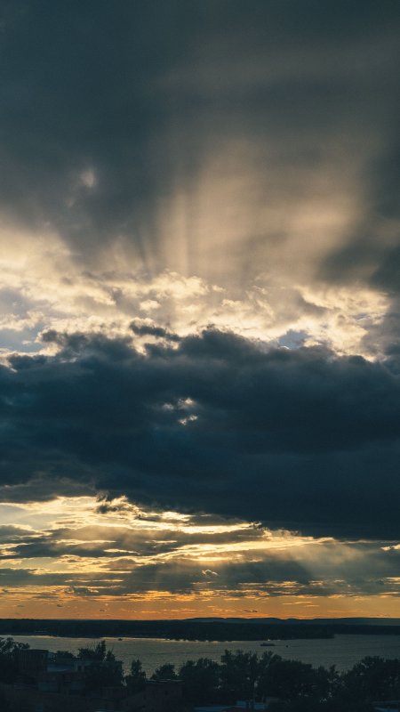 夕阳穿透云层金光洒落湖面暗蓝风景手机壁纸