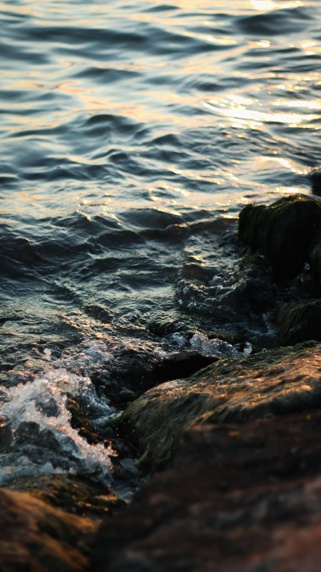 海浪轻拍礁石金辉波光风景手机壁纸