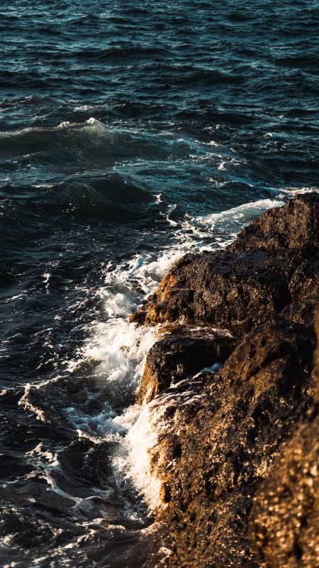 海浪拍打礁石金蓝光影风景手机壁纸