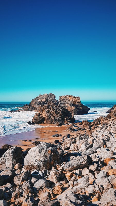 海岸礁石浪花拍岸蓝白风景手机壁纸