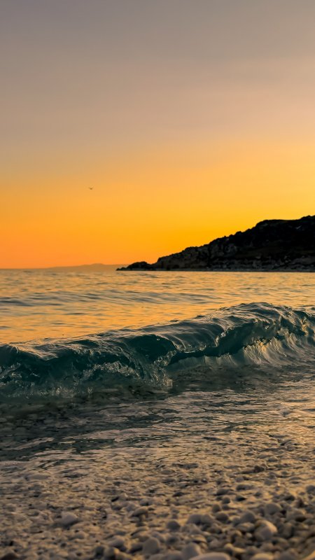 海浪拍岸金色夕阳暖橙风景手机壁纸