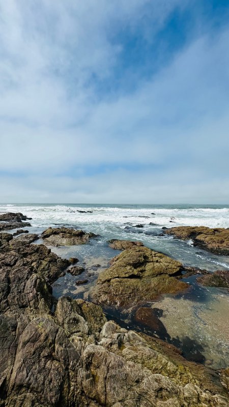 海岸礁石浪花拍打蓝白自然风景手机壁纸