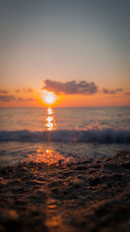 海边日落余晖洒岸橙金风景手机壁纸
